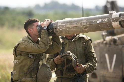 An Israeli soldier looks into a barrel of a tank on the Israeli border with the Gaza Strip on October 19, 2023 in Sderot, Israel.