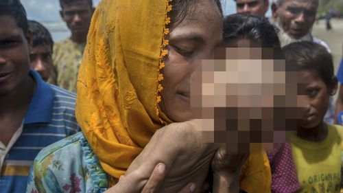 Hanida Begum, who crossed over from Myanmar into Bangladesh, kisses her infant son Abdul Masood who died when the boat they were travelling in capsized. (AP)