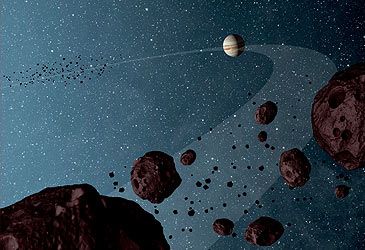 By what name are the asteroids that share Jupiter's orbit around the Sun known?