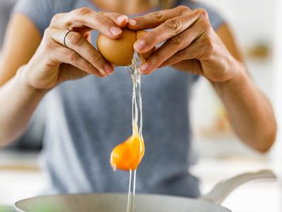 Woman cracking an egg into a bowl photo