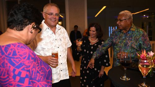 Prime Minister of Fiji Frank Bainimarama points to Australian Prime Minister Scott Morrison's sulu vaka taga as he arrives in traditional Bula dress with his wife Jenny to an official dinner.