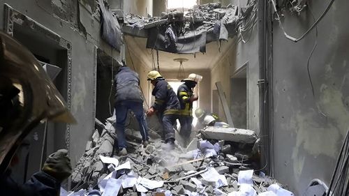 Ukrainian Emergency Service personnel inspecting the damage inside the City Hall building in Kharkiv, Ukraine, Tuesday, March 1, 2022. 