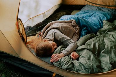 Woman sleeping in a tent with a sleeping bag