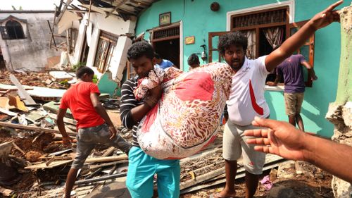 Survivors move items from destroyed homes now buried under the collapsed garbage mountain in Colombo, Sri Lanka. (AFP)