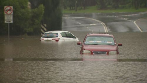 Cars are almost fully submerged in floodwaters that inundated Western Sydney overnight. 