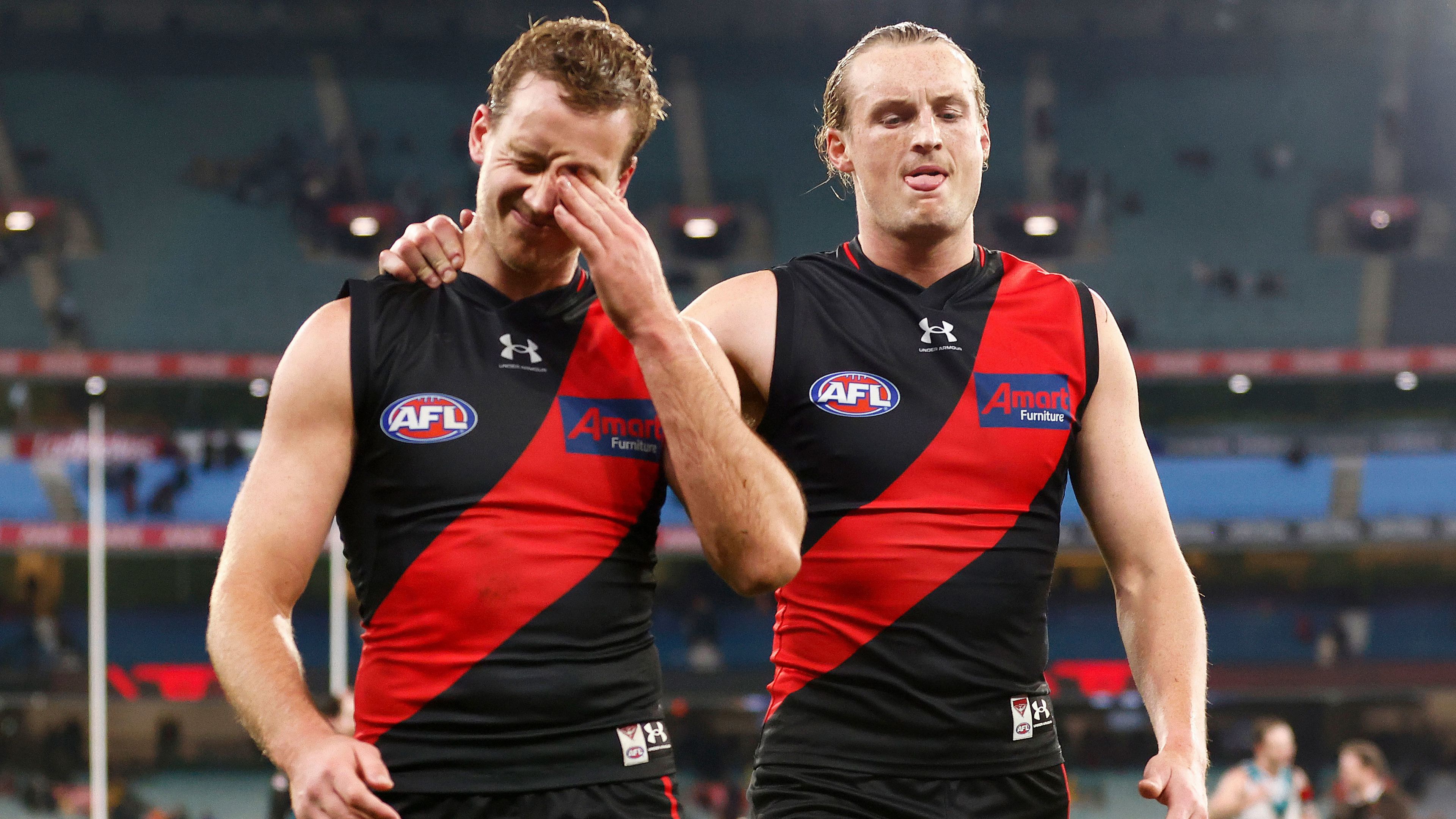 Darcy Parish (left) and Mason Redman of the Bombers look dejected as they leave the field after their round 16 loss to Port Adelaide.