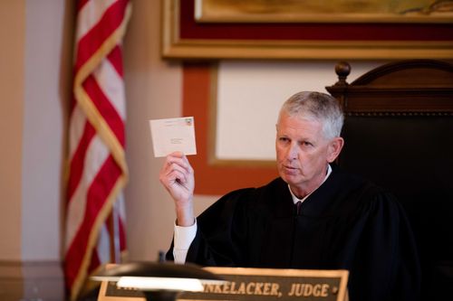 Judge Patrick T. Dinkelacker reads cards he said he received at his home in an apparent effort to intimidate him during an execution of sentence of Former judge Tracie Hunter.