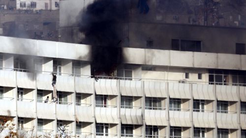 People use fabric to jump from the Intercontinental Hotel after an attack by armed gunmen in Kabul, Afghanistan. (AAP)
