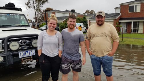 The heroic trio snapped in floodwaters outside the rescue.