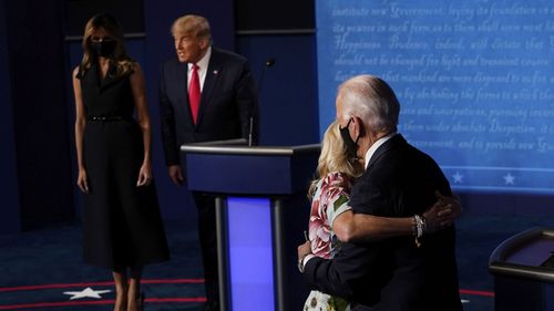 Candidatul democrat la președinție, fostul vicepreședinte Joe Biden, își îmbrățișează soția Jill Biden, în timp ce președintele Donald Trump stă lângă prima doamnă Melania Trump.