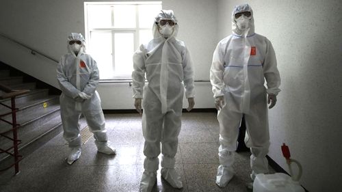 Health officials prepare to spray disinfectant at a high school in South Korea, during the first wave of the coronavirus pandemic.