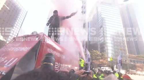 The protester was doused with a fire extinguisher. (9NEWS)