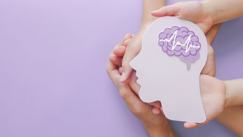 Mani di adulti e bambini che tengono ritaglio di carta cerebrale per encefalografia, autismo, ictus, epilessia e consapevolezza dell'alzheimer, disturbi convulsivi, ictus, ADHD, concetto di giornata mondiale della salute mentale