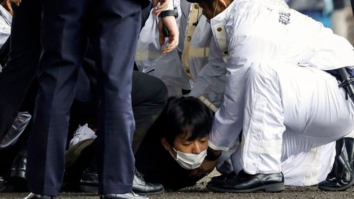 مردی روی زمین که بمب دودزا را پرتاب کرده بود توسط پلیس دستگیر شد.