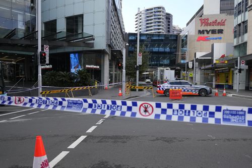 Police block a street near a crime scene at Bondi Junction in Sydney, Sunday, April 14, 2024, after several people were stabbed to death at a shopping center Saturday. Police have identified Joel Cauchi, 40, as the assailant that stabbed several people to death at a busy Sydney shopping center Saturday before he was fatally shot by a police officer. (AP Photo/Rick Rycroft)