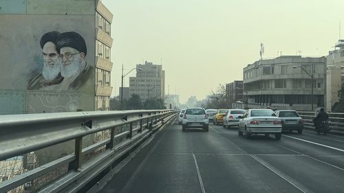 Vehicles drive past portrait of the late Iranian revolutionary founder Ayatollah Khomeini, left, and Supreme Leader Ayatollah Ali Khamenei, in downtown Tehran. the theocracy has struggled to deal with dissent in recent weeks.