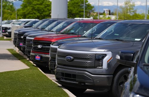 F150 and Lightning electric pickup trucks sit at a Ford dealership on May 19, 2024, in Denver 