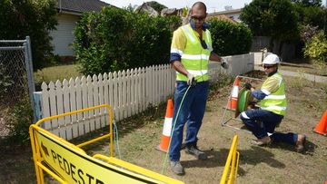 Workers installing a fibre optic cable as part of the National Broadband Network rollout. (AAP)