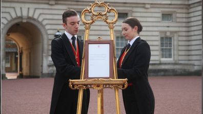 Footmen Stephen Kelly and Sarah Thompson bring out the easel in the forecourt of Buckingham Palace in London to formally announce the birth of a baby boy to the Duke and Duchess of Sussex