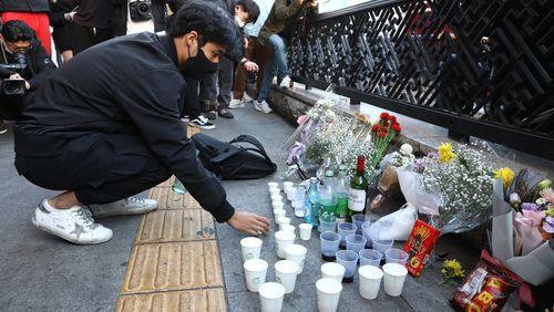 A man lights a candle at the street of a deadly stampede during a Halloween festival in Seoul, South Korea.