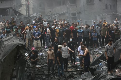 Palestinesi ispezionano i danni agli edifici distrutti a seguito degli attacchi aerei israeliani su Gaza City, venerdì 27 ottobre 2023.
