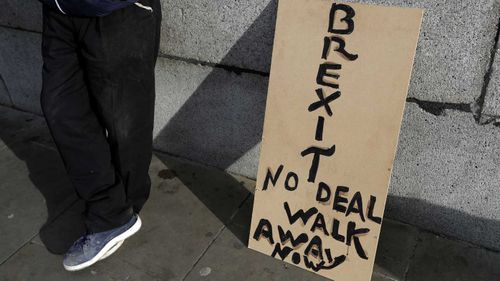 A banner leans on a wall near to parliament in London.