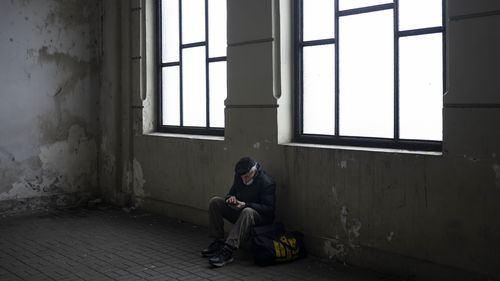 An elderly man waits for a train to Poland inside Lviv railway station.