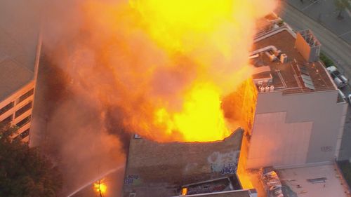 Plumes of smoke are drifting over Sydney as huge flames billow from a seven-storey building in Surry Hills.