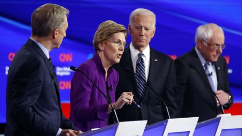 Elizabeth Warren speaks during the debate as Tom Steyer, Joe Biden and Bernie Sanders.