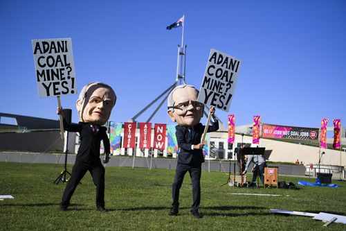 Anti-Adani coal mine protesters wearing big puppet heads of Scott Morrison and Bill Shorten are making a lot of noise outside parliament.