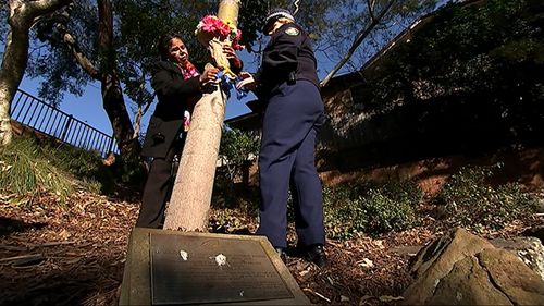 Julianne Szabo hangs flowers on a tree planted in memory of her son may years ago. (9NEWS)