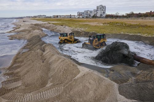 Contractors for the US Army Corps of Engineers pump sand from the ocean floor onto the beach in the Rockaway Peninsula in New York City on Tuesday, Oct. 18, 2022. 