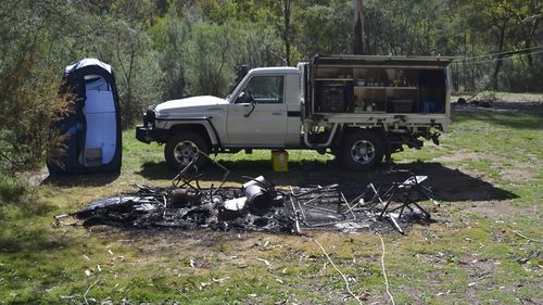 Tendered photos of Russell Hill and Carol Clay's burnt-out campsite were shown to the jury.