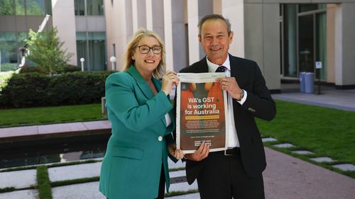 A vice-primeira-ministra e tesoureira da Austrália Ocidental Rita Saffioti (L) e o primeiro-ministro da Austrália Ocidental Roger Cook (R) posam com um artigo de jornal na Casa do Parlamento em 5 de novembro de 2025 em Canberra, Austrália.