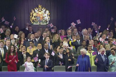 Queen Camilla, front third right, and King Charles III, front second right, join in the fun with other members of the royal family and guests in the Royal Box during the concert at Windsor Castle in Windsor, England, Sunday, May 7, 2023, celebrating the coronation of King Charles III.