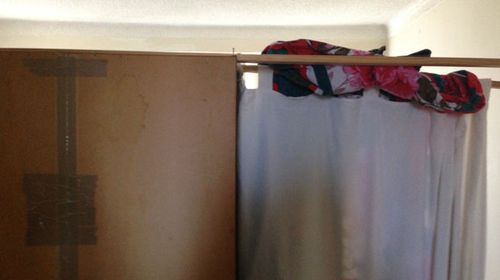Crude plywood, stuck together with duct tape, acts as a wall separating the lounge room and the living area at Strathfield. (Supplied)