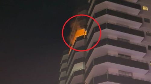 A man has been filmed scaling a building after a fire broke out inside a high-rise unit.