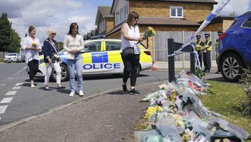 Family friend Lea Holloway, left, arrives with others to place tributes following the deaths of three women who were killed in an attack at their home, on Tuesday in Bushey, England, Thursday July 11, 2024.  
