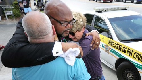 Kelvin Cobaris, a local clergyman, consoles Orlando city commissioner Patty Sheehan, right, and Terry DeCarlo, an Orlando gay-rights advocate, as they arrive on the scene. (Orlando Sentinal/AP)