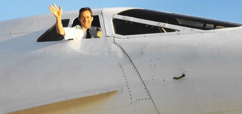 Concorde pilot John Tye waves out the window.