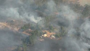 Aerial images show smoke billowing from the bushfire.