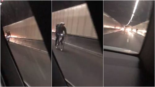 A cyclist was filmed riding down Sydney's busy M5 Motorway, holding up traffic yesterday.
