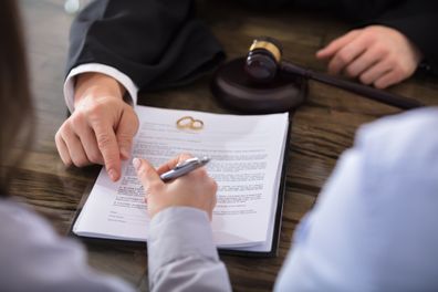 Mujer firmando papeles de divorcio