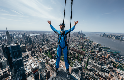 City Climb: Man leans off corner of skyscraper in NYC with harness