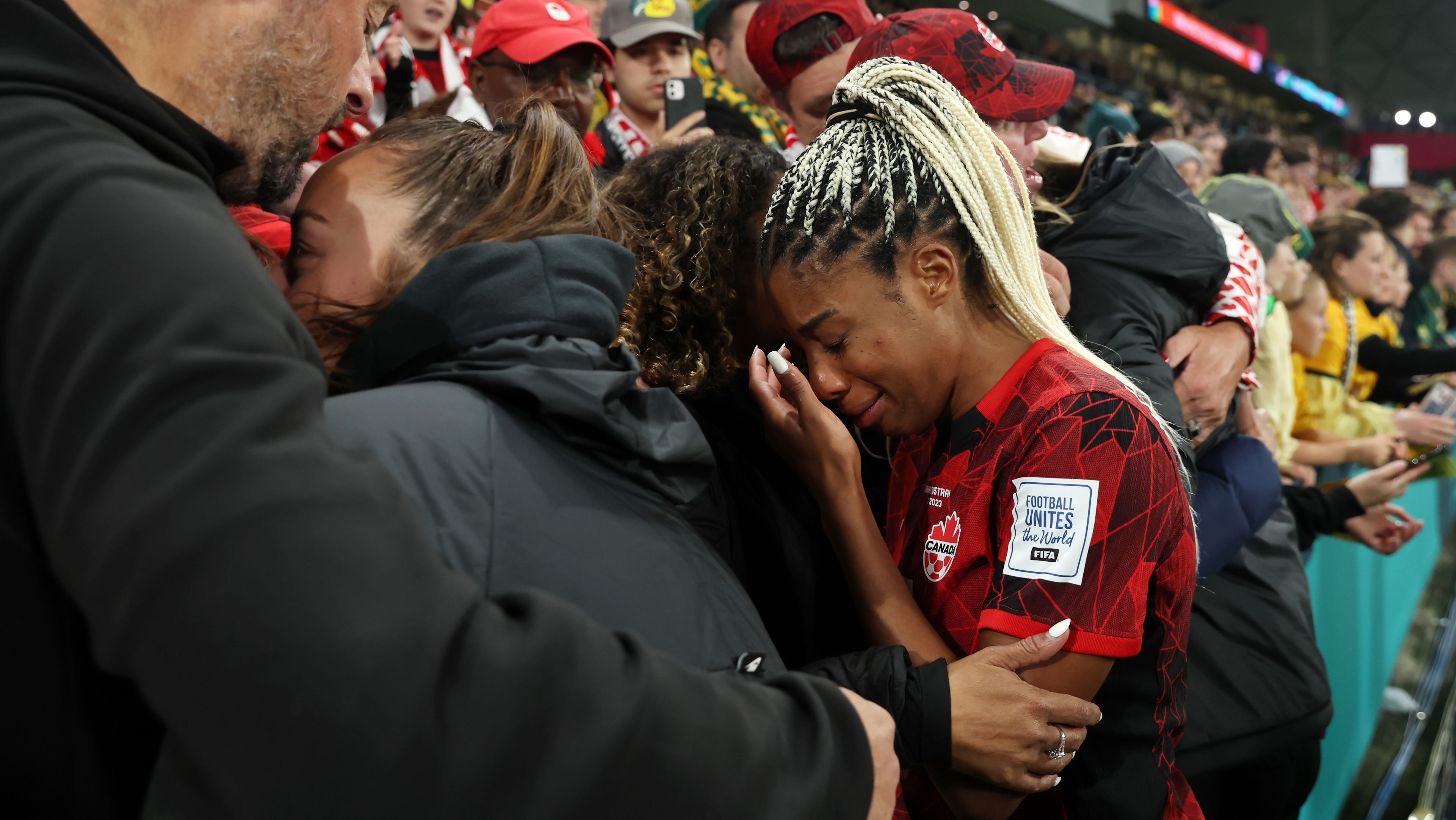 MELBOURNE, AUSTRALIA - JULY 31: Ashley Lawrence of Canada is consoled by her family after the team&#x27;s 0-4 defeat and elimination from the tournament following the FIFA Women&#x27;s World Cup Australia &amp; New Zealand 2023 Group B match between Canada and Australia at Melbourne Rectangular Stadium on July 31, 2023 in Melbourne / Naarm, Australia. (Photo by Alex Grimm - FIFA/FIFA via Getty Images)
