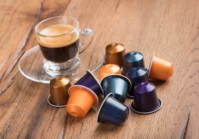 Berlin, Germany - January 23, 2015: Cup of Coffee with Nestle Nespresso Capsules on a wooden table