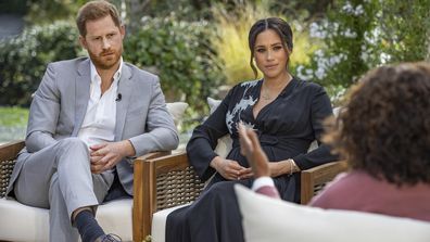 This image provided by Harpo Productions shows Prince Harry, from left, and Meghan, The Duchess of Sussex, in conversation with Oprah Winfrey. (Joe Pugliese/Harpo Productions via AP)