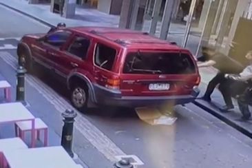 A major manhunt is underway for a man who stole a car in a Melbourne laneway. The owner was left with serious injuries after he clung onto the bonnet of his car to stop thief from driving off. 