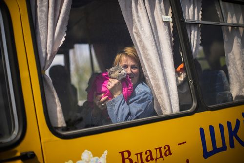 A woman waits in a bus to be processed as she arrives to a reception center for displaced people in Zaporizhzhia, Ukraine, Monday, May 2, 2022. Thousands of Ukrainian continue to leave Russian occupied areas. (AP Photo/Francisco Seco