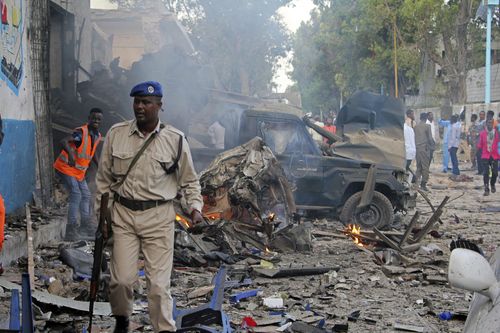 A Somali soldier walks near wreckage of vehicles after a car bomb was detonated in Mogadishu. (AP)